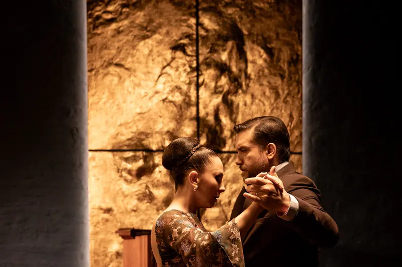 A couple dancing close together in a warm-lit room