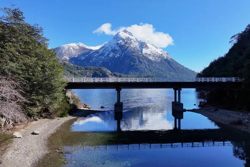 A bridge over a channel, with mountains behind