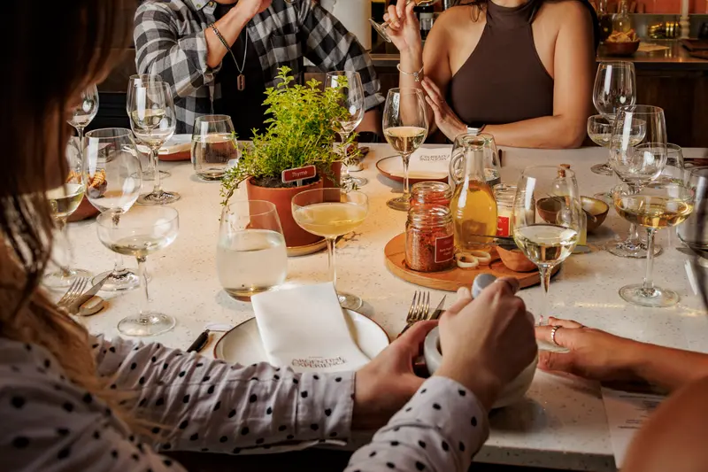 Guests around the table with wine glasses in front of them