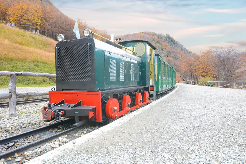 The End of the World train at the platform, with autumn trees behind it