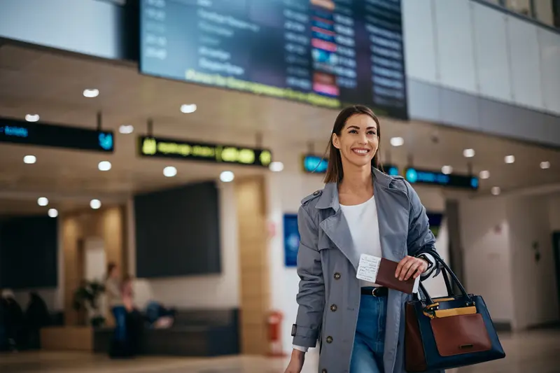 A traveller with a bag walking through an airport terminal