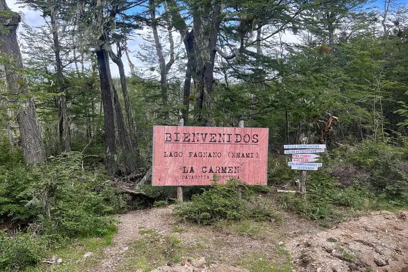 A wooden welcome sign at Lago Fagnano, in the woods