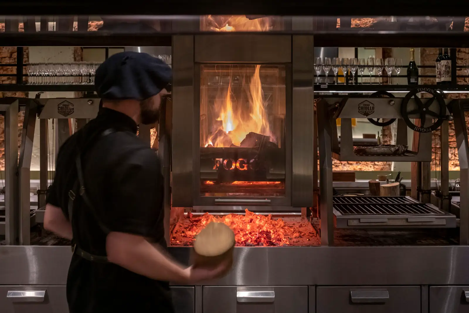 A cook at a wood-fired grill