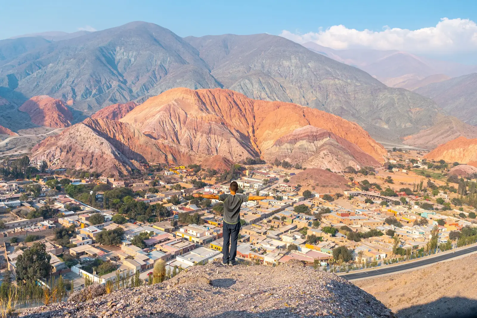 A visitor looking out at the coloured hills above Purmamarca