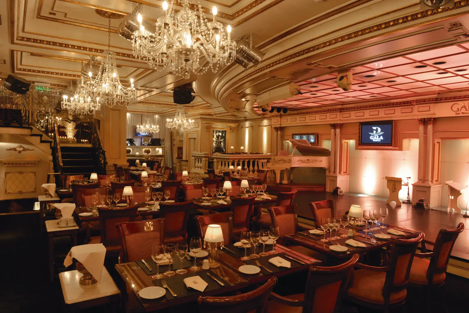 A tango hall with chandeliers, the tables set before the show